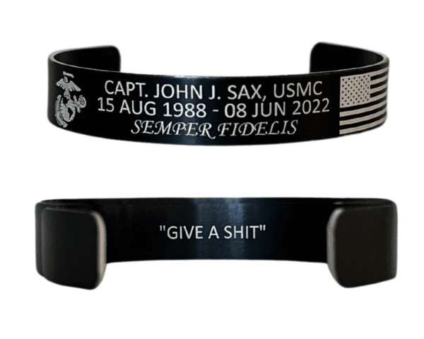 A black bracelet with the words " give a shit ".